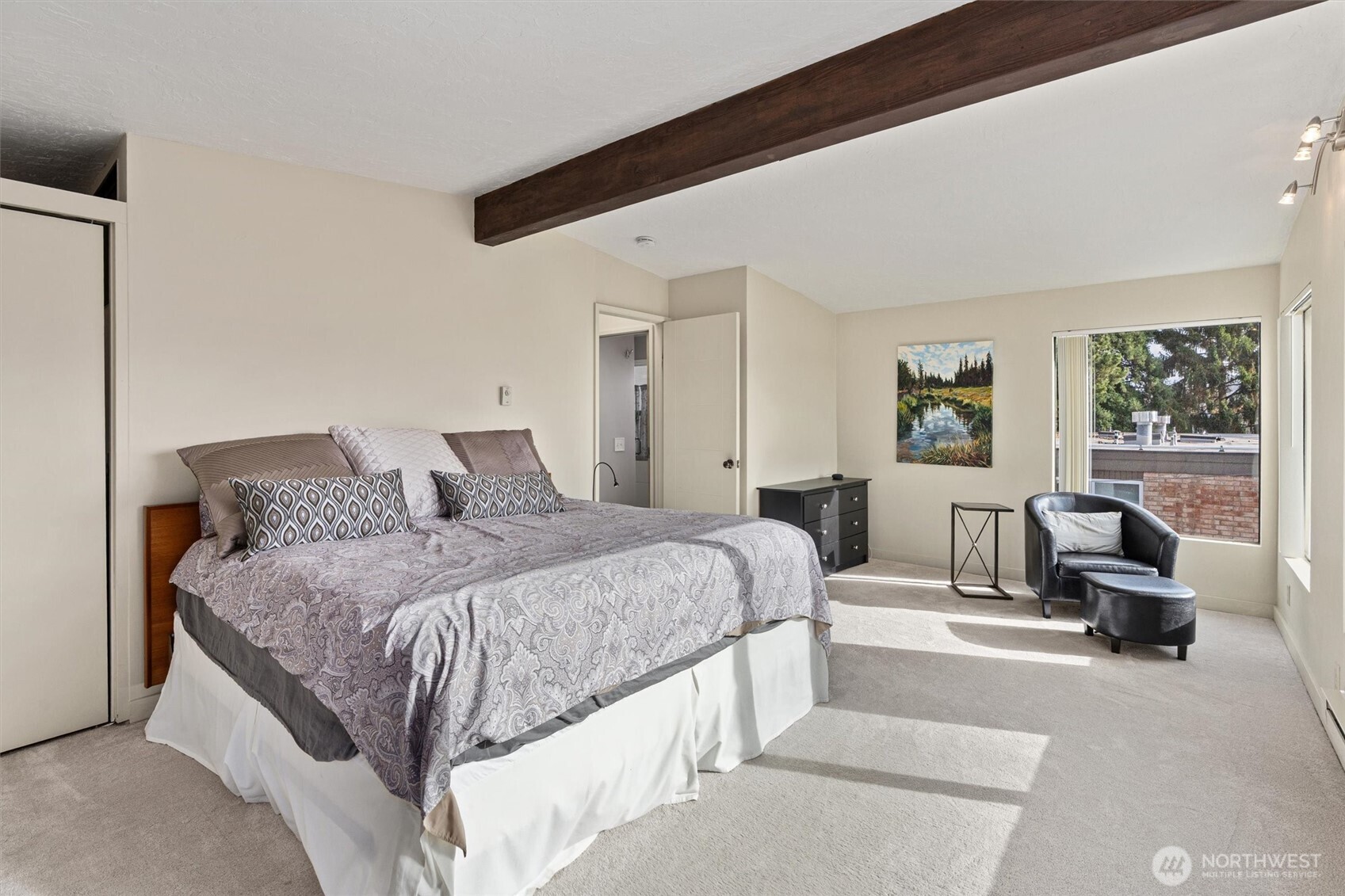 561 Lee Street Seattle, WA 98109 - Photo 18 of 40 a spacious bedroom with a bed a couch and large window