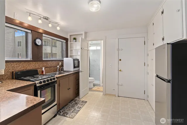a kitchen with stainless steel appliances granite countertop a refrigerator and a stove top oven