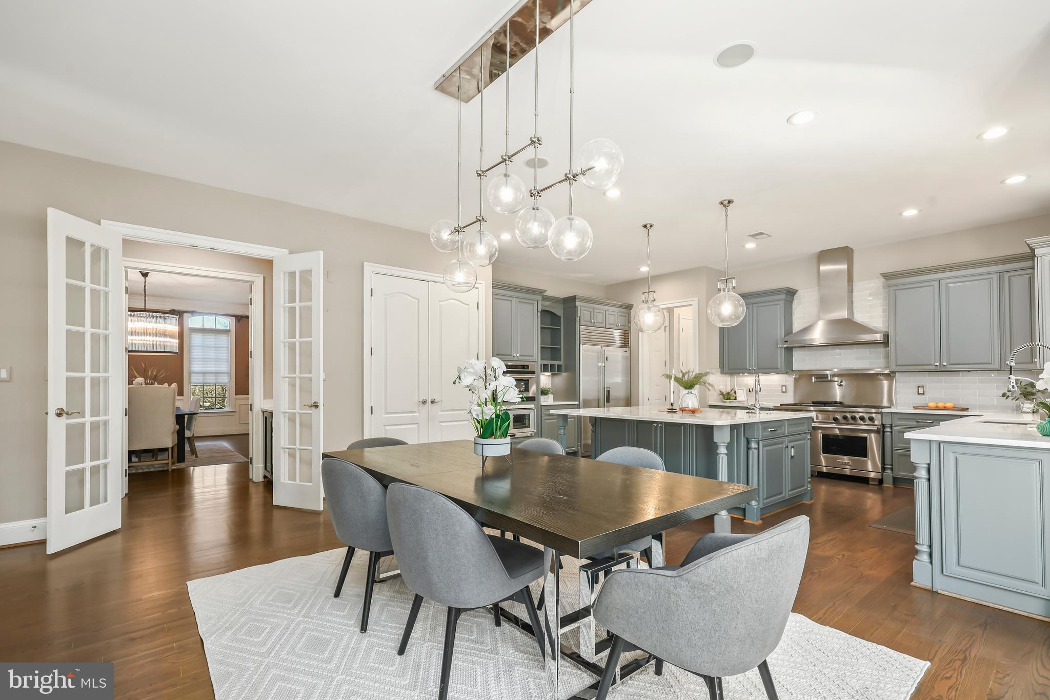 8340 Springhaven Garden Lane McLean, VA 22102 - Photo 13 of 76 a dining room with kitchen island a dining table wooden floor stainless steel appliances and cabinets