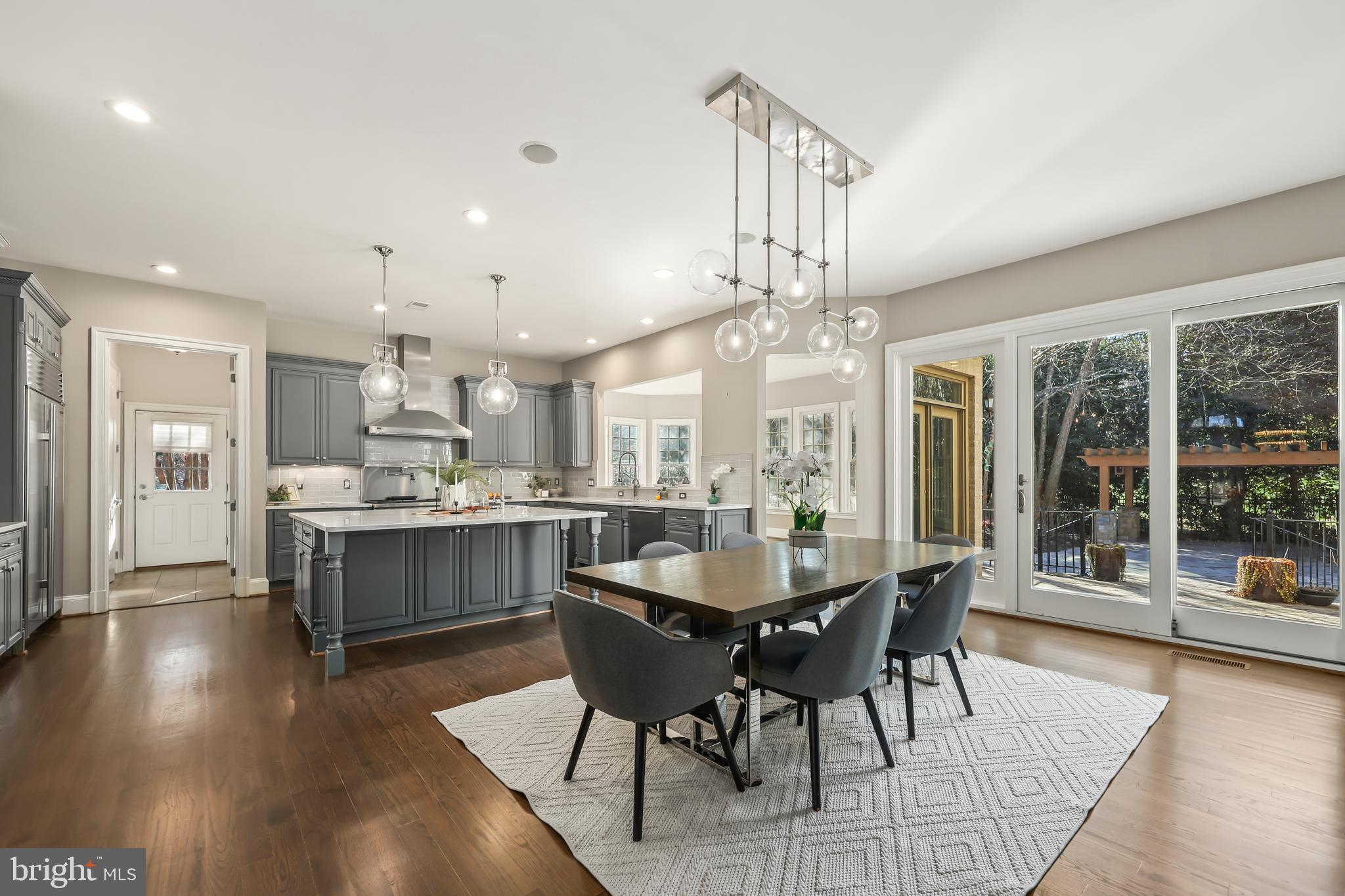 8340 Springhaven Garden Lane McLean, VA 22102 - Photo 14 of 76 a dining room with wooden floor a chandelier a wooden table and chairs