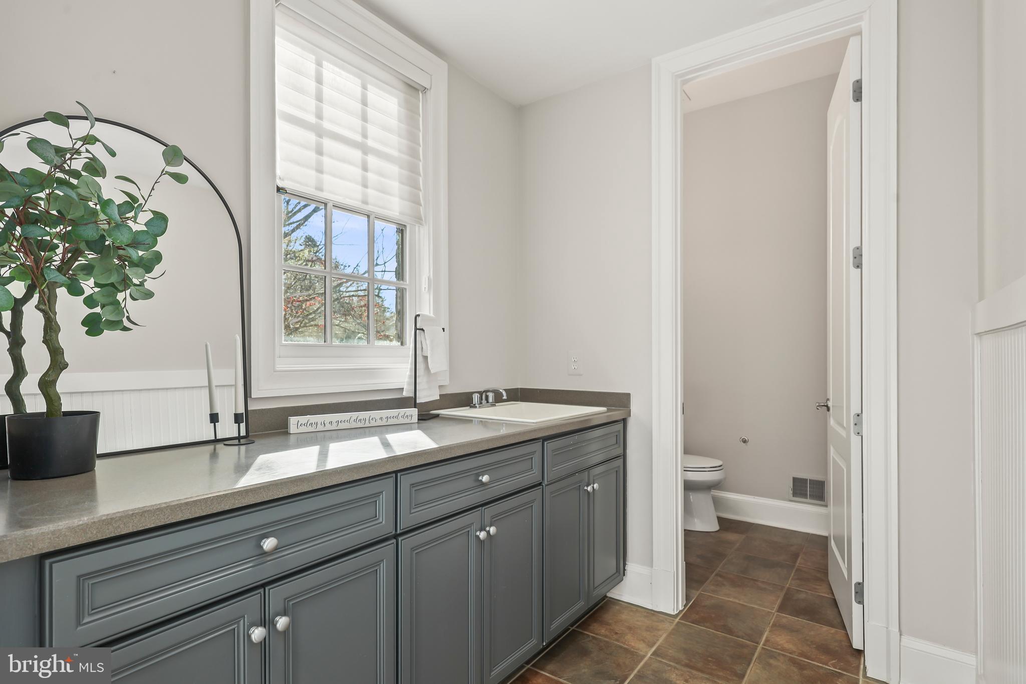8340 Springhaven Garden Lane McLean, VA 22102 - Photo 21 of 76 a bathroom with a granite countertop sink a toilet and a window