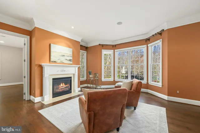 a dining room with kitchen island a dining table wooden floor stainless steel appliances and cabinets