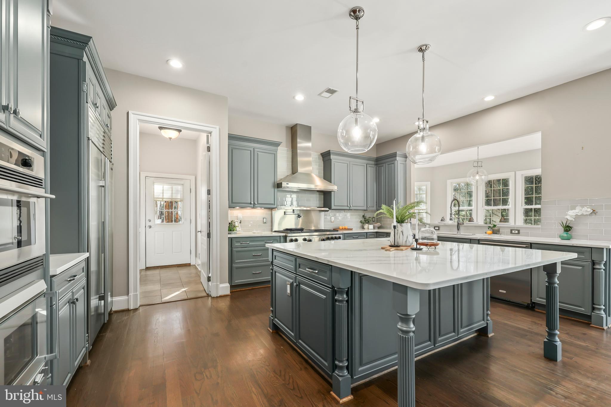 8340 Springhaven Garden Lane McLean, VA 22102 - Photo 10 of 76 a kitchen with kitchen island a stove a sink a center island and a wooden floor