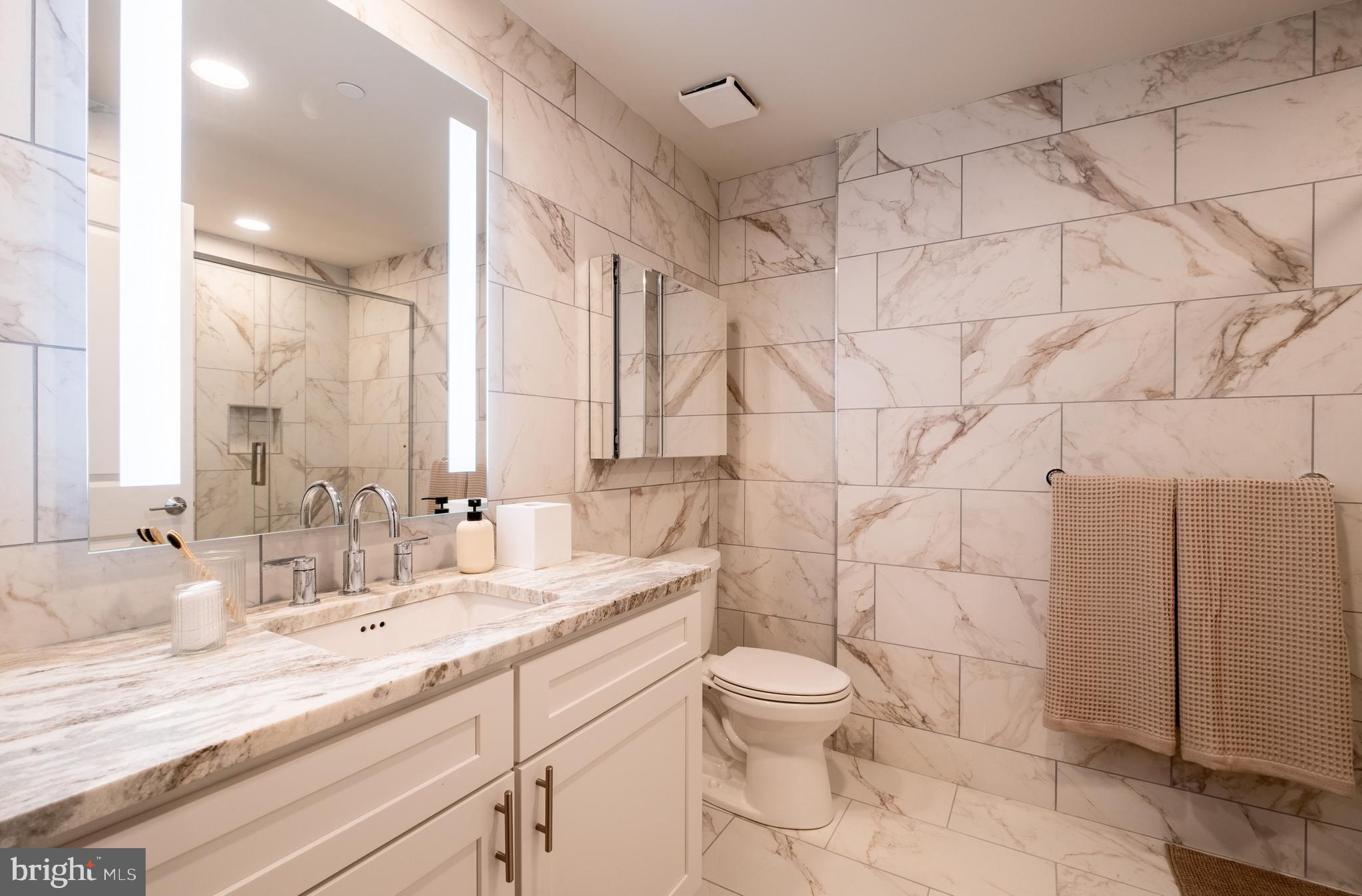 2301-61 John F Kennedy Boulevard, Unit 209 Philadelphia, PA 19103 - Photo 11 of 36 a bathroom with a granite countertop sink a toilet and a mirror