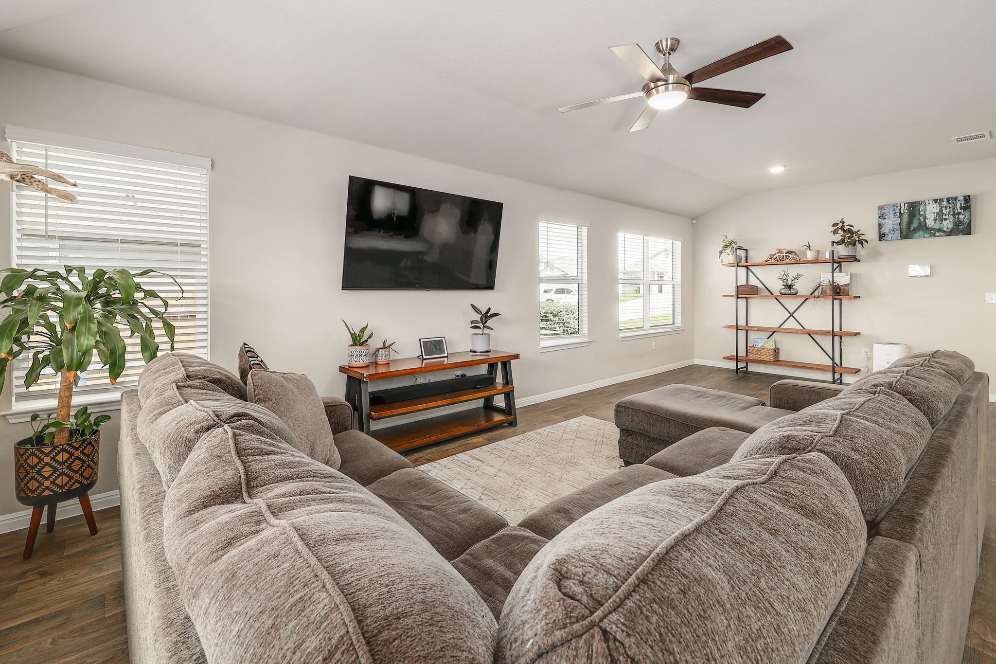 413 Hunter Loop Bertram, TX 78605 - Photo 4 of 27 A well-lit living area features large windows providing natural light and a stylish ceiling fan for comfort.