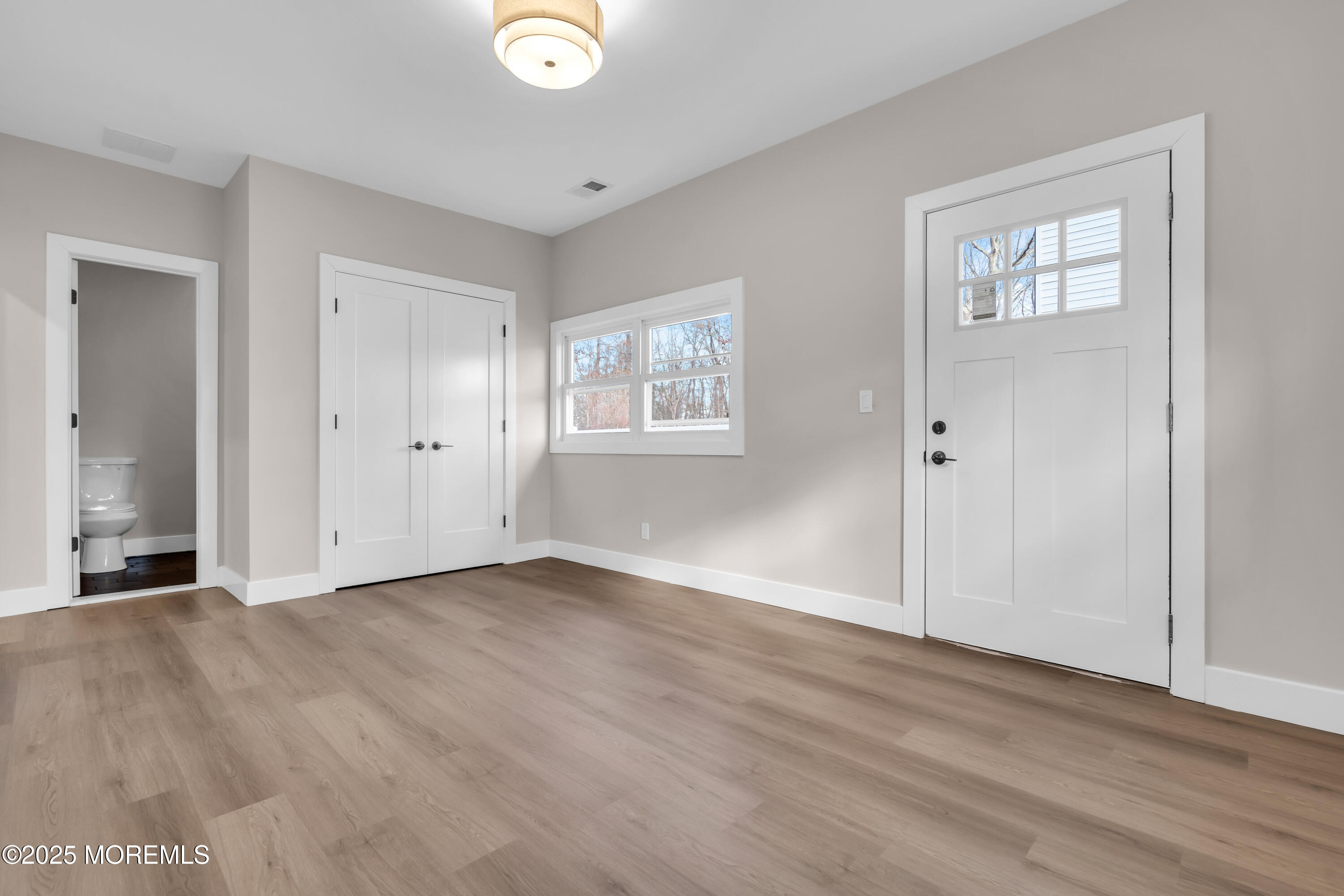 170 Station Road Bayville, NJ 08721 - Photo 26 of 36 an empty room with wooden floor and windows