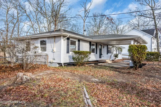 a view of a house with a yard and large tree