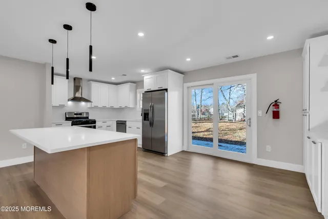 a kitchen island with stainless steel appliances kitchen island wooden floor and window