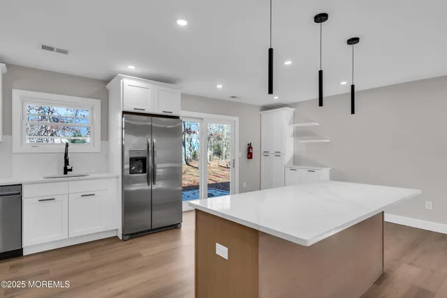 a kitchen with kitchen island a counter top space cabinets and stainless steel appliances