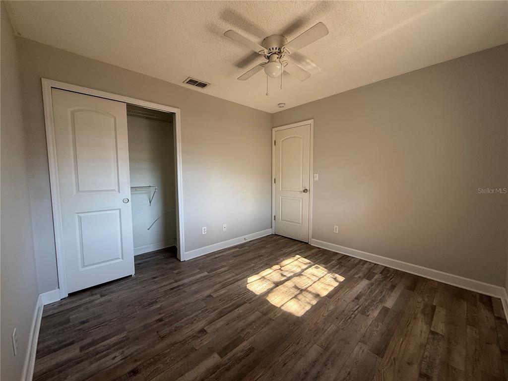 5839 12th Street Zephyrhills, FL 33542 - Photo 14 of 20 an empty room with wooden floor and windows