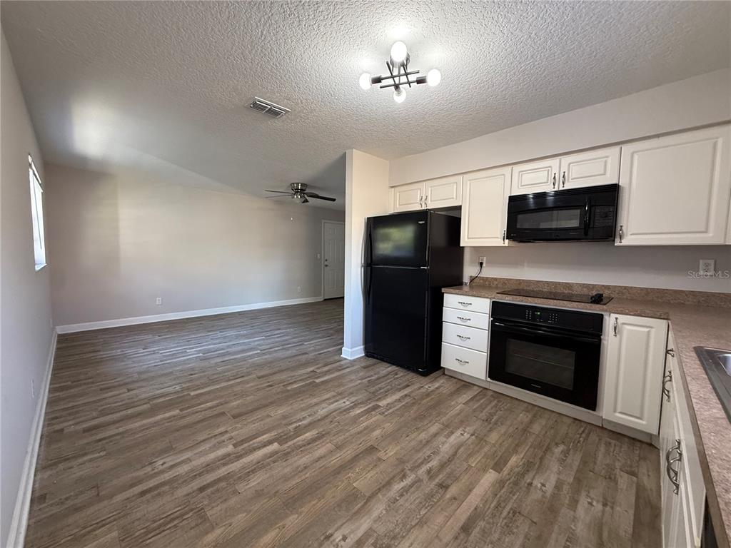 5839 12th Street Zephyrhills, FL 33542 - Photo 5 of 20 a view of kitchen with a microwave and a refrigerator
