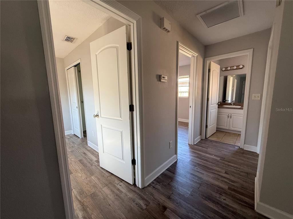 5839 12th Street Zephyrhills, FL 33542 - Photo 8 of 20 a view of a hallway with wooden floor and a cabinet