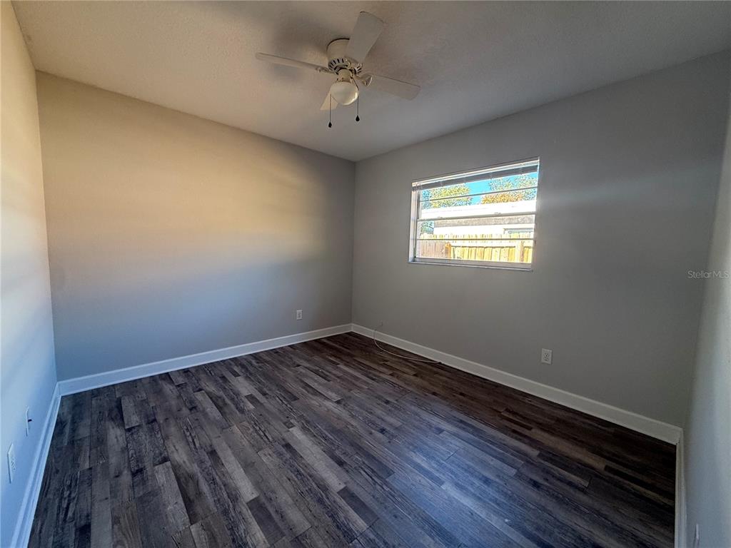 5839 12th Street Zephyrhills, FL 33542 - Photo 9 of 20 a view of an empty room with wooden floor and a window