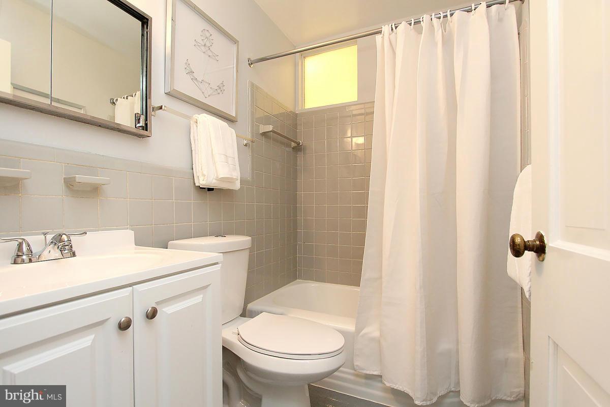 10109 Portland Place Silver Spring, MD 20901 - Photo 20 of 26 a bathroom with a sink a toilet and shower curtain