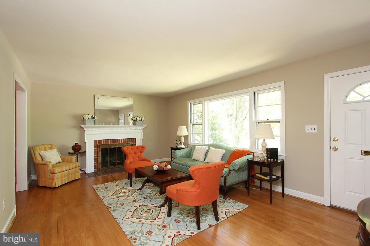 10109 Portland Place Silver Spring, MD 20901 - Photo 4 of 26 a living room with furniture a fireplace and a table