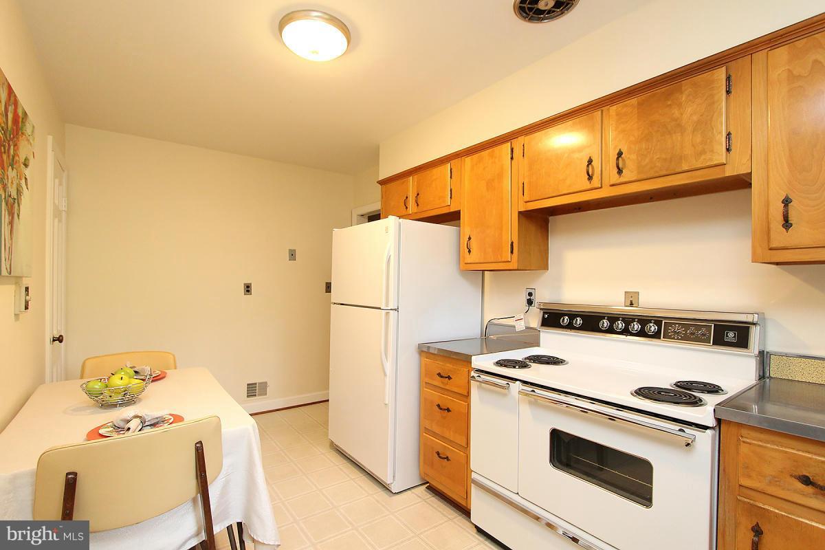 10109 Portland Place Silver Spring, MD 20901 - Photo 10 of 26 a kitchen with a stove a refrigerator and a cabinets