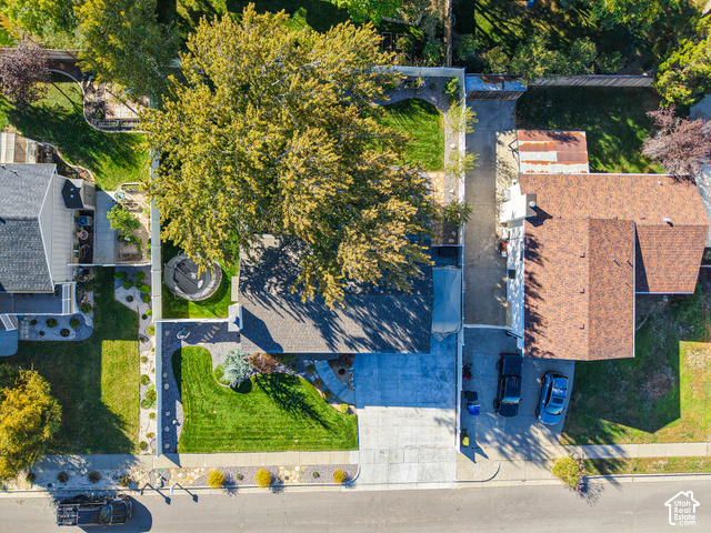3308 Willow Ridge Road Salt Lake City, UT 84121 - Photo 19 of 59 Manicured lawn, mature trees, concrete driveway, stone garden beds, and bark mulch landscaping
