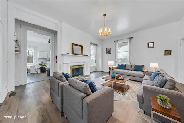 a view of a livingroom with wooden floor and a fireplace