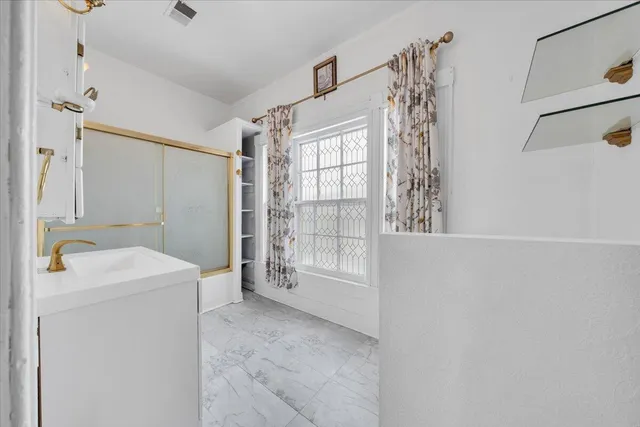 a bathroom with a sink a toilet and shower