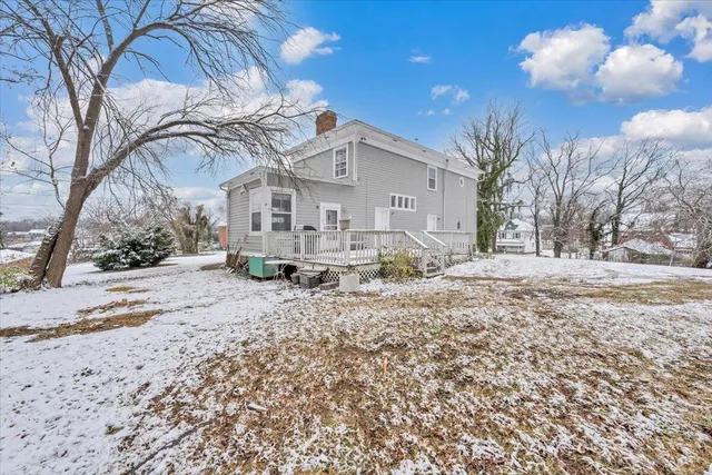 a front view of a house with a yard covered in snow