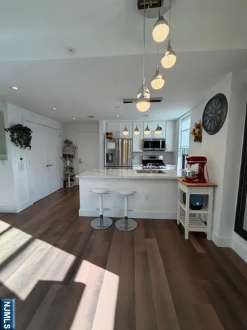 a large living room with stainless steel appliances granite countertop furniture a fireplace and a view of kitchen