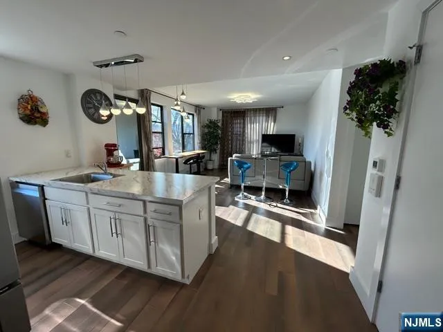 a living room with furniture a potted plant and a large window