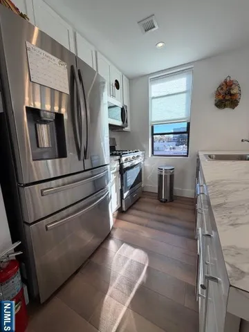 a living room with furniture a chandelier and a large window