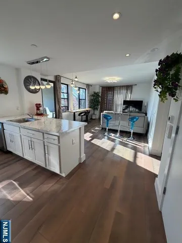 a living room with furniture a wooden floor and a flat screen tv