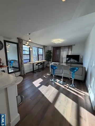 a room with furniture a flat screen tv and a wall painting