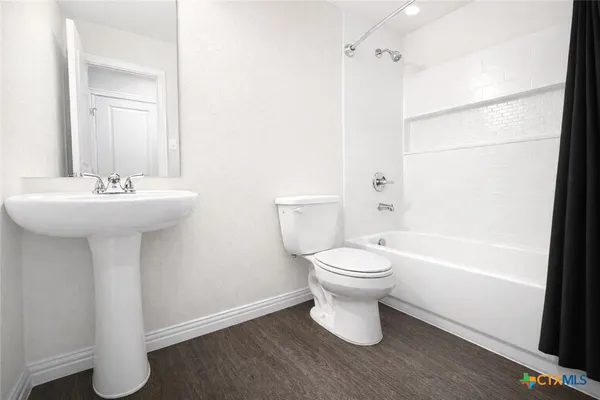 a bathroom with a white sink a toilet and shower
