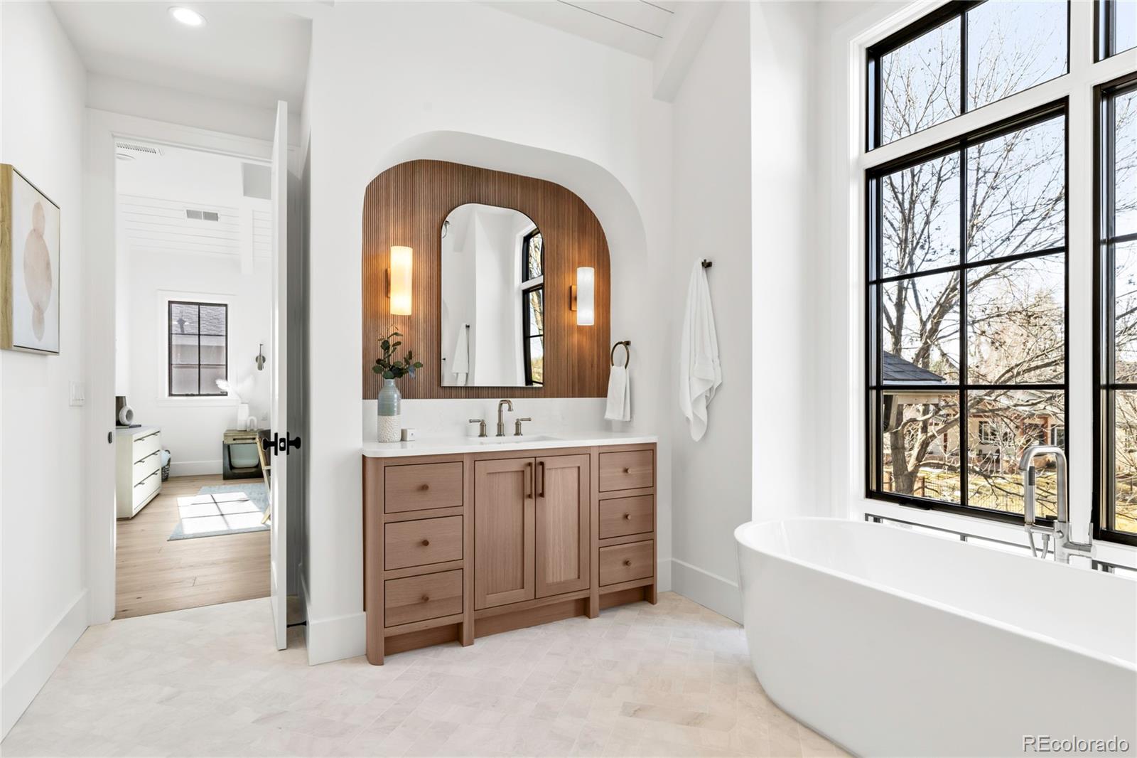 2658 South Adams Street Denver, CO 80210 - Photo 25 of 34 a en suite bathroom with a granite countertop tub and a large window