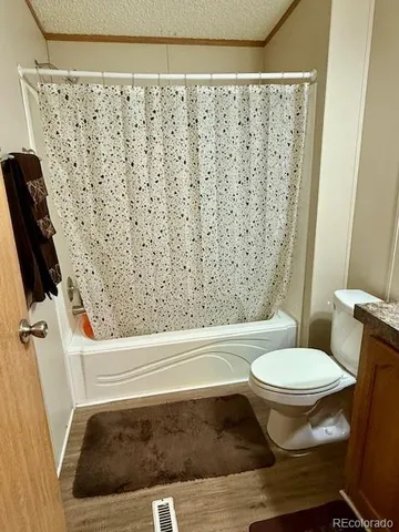 a bathroom with a toilet and a shower curtain
