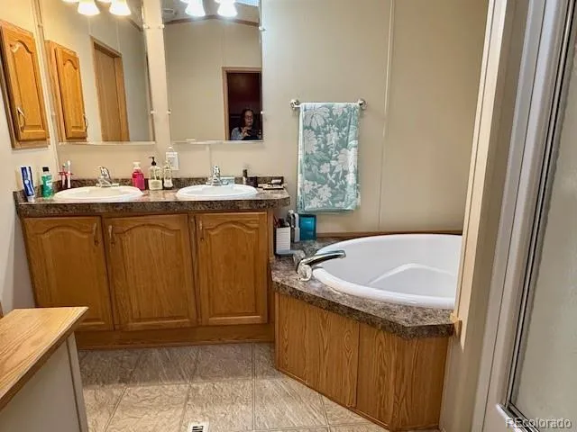 a bathroom with a tub sink and mirror