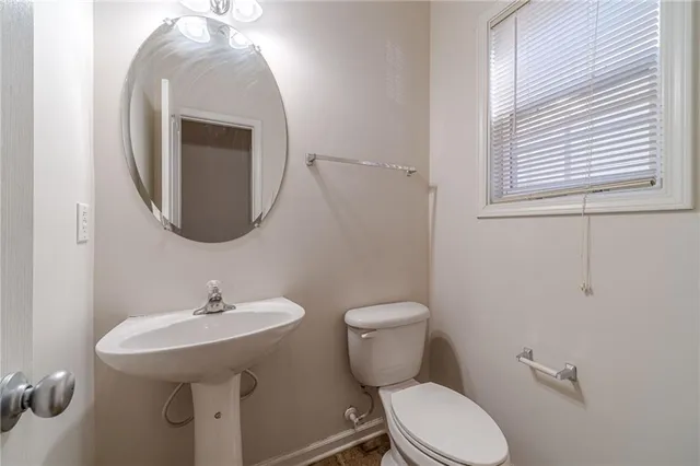 a bathroom with a toilet sink and mirror