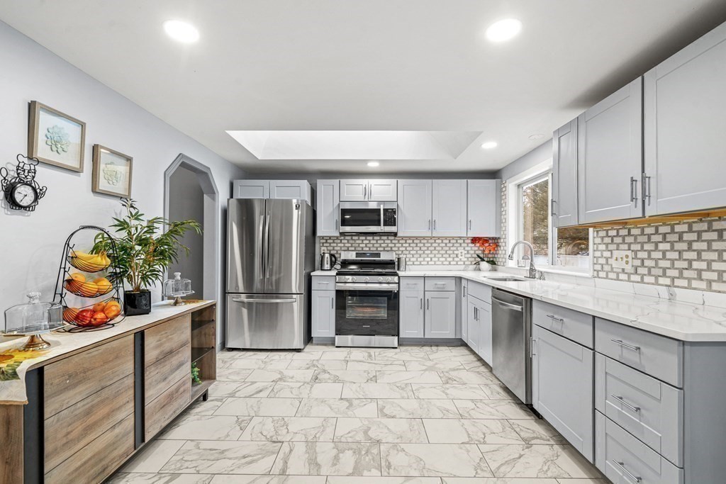 28 Sycamore Road Methuen, MA 01844 - Photo 11 of 35 a kitchen with stainless steel appliances a stove a sink and a refrigerator