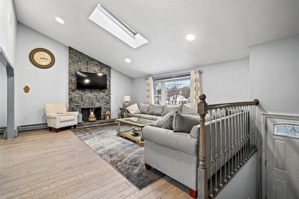 28 Sycamore Road Methuen, MA 01844 - Photo 4 of 35 a living room with furniture a fireplace and a flat screen tv