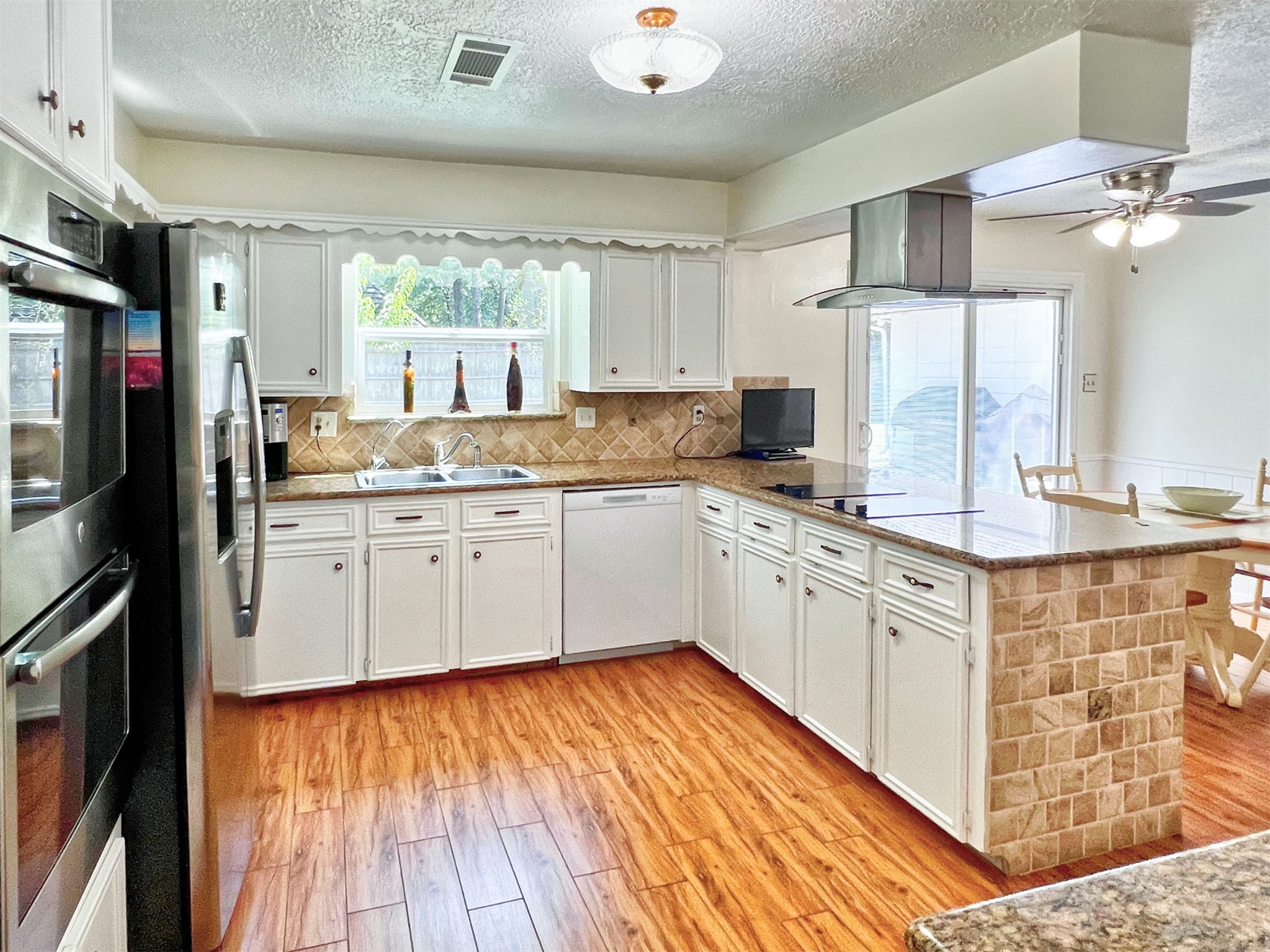 16902 Summit Oaks Lane Spring, TX 77379 - Photo 21 of 49 a kitchen with stainless steel appliances a sink cabinets and wooden floor