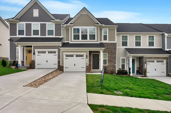 a front view of a house with a yard and a garage