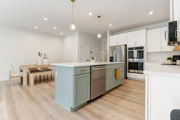 a kitchen with a sink chairs and wooden floor