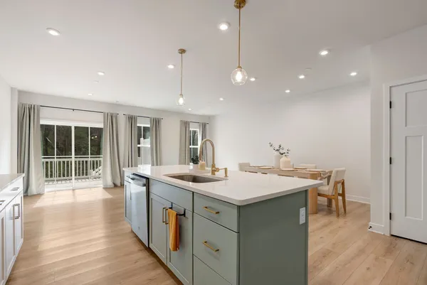 a kitchen with a sink a stove and wooden floor