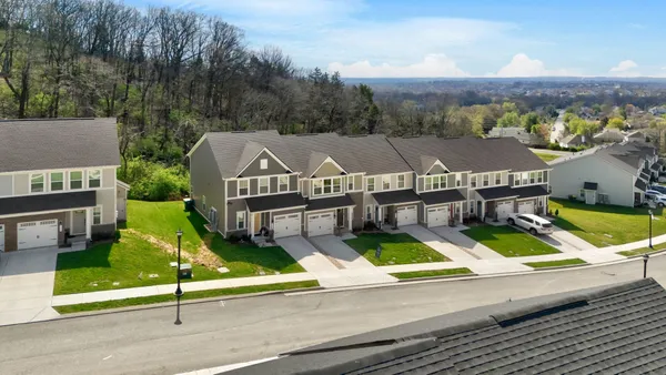an aerial view of residential houses with yard and ocean view