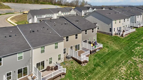 an aerial view of residential houses with outdoor space and parking