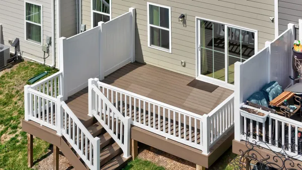 a view of a house with wooden deck and wooden fence
