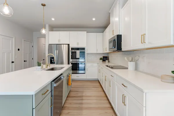 a large kitchen with stainless steel appliances kitchen island granite countertop a sink and refrigerator