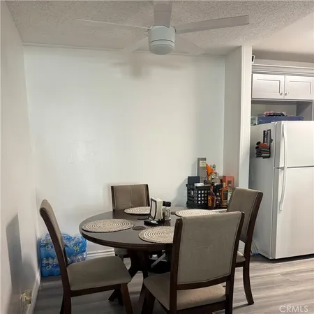 a kitchen with a refrigerator a stove a sink dishwasher and white cabinets with wooden floor