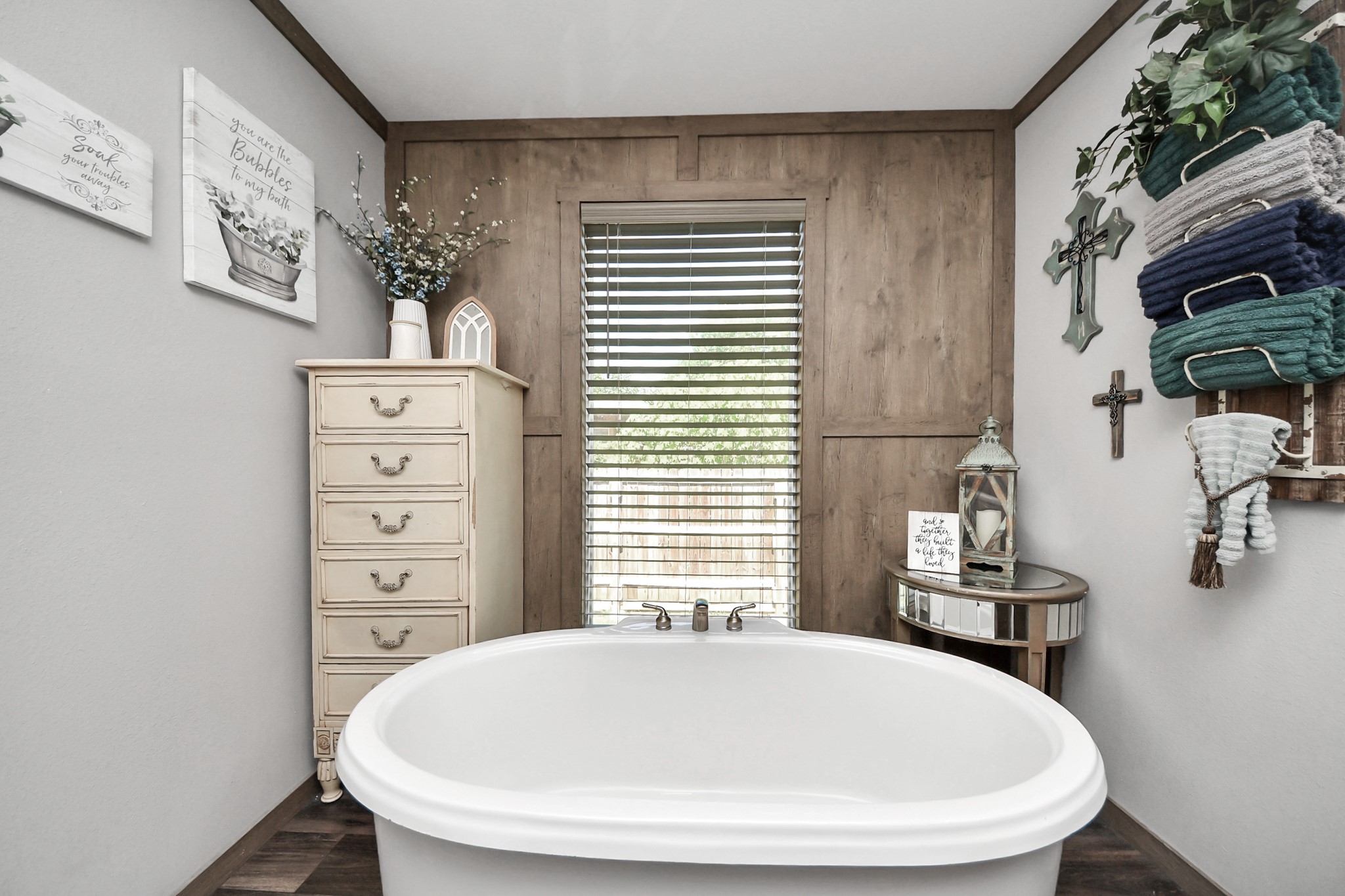 131 Kiowa Court Rosharon, TX 77583 - Photo 21 of 42 This cozy bathroom features a freestanding bathtub, accented by a wooden wall with a window and blinds