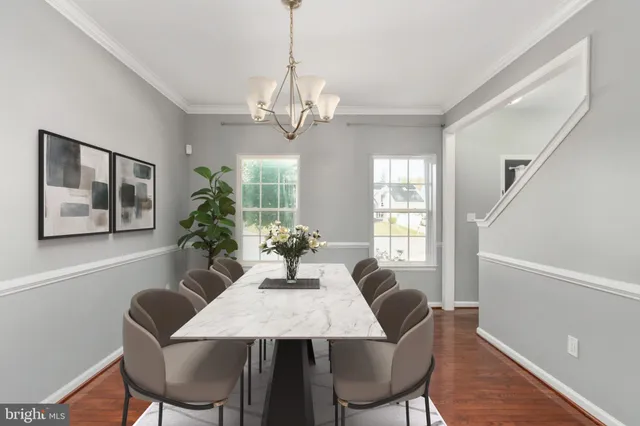 a kitchen with a dining table chairs and a wooden floor
