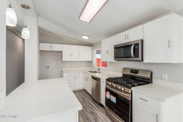 a kitchen with sink a microwave and cabinets