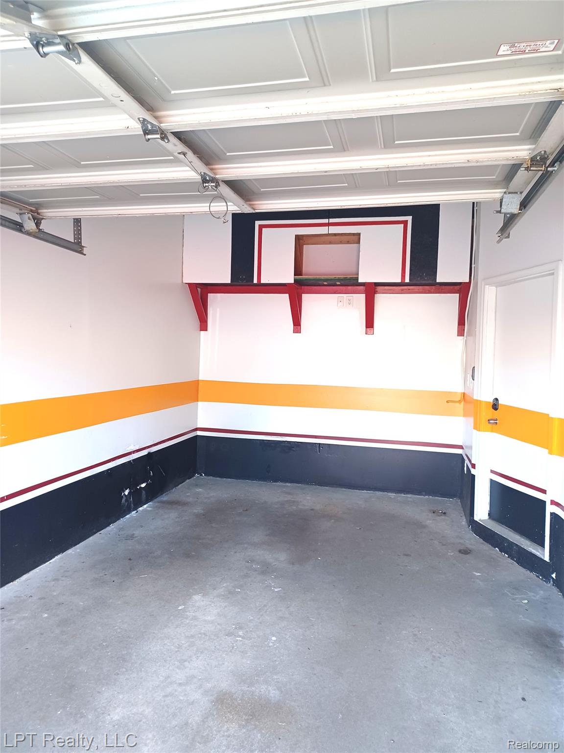 3304 Spinnaker Lane, Unit 47 Detroit, MI 48207 - Photo 21 of 21 Interior garage space featuring a concrete floor, painted walls, and a paneled overhead garage door
