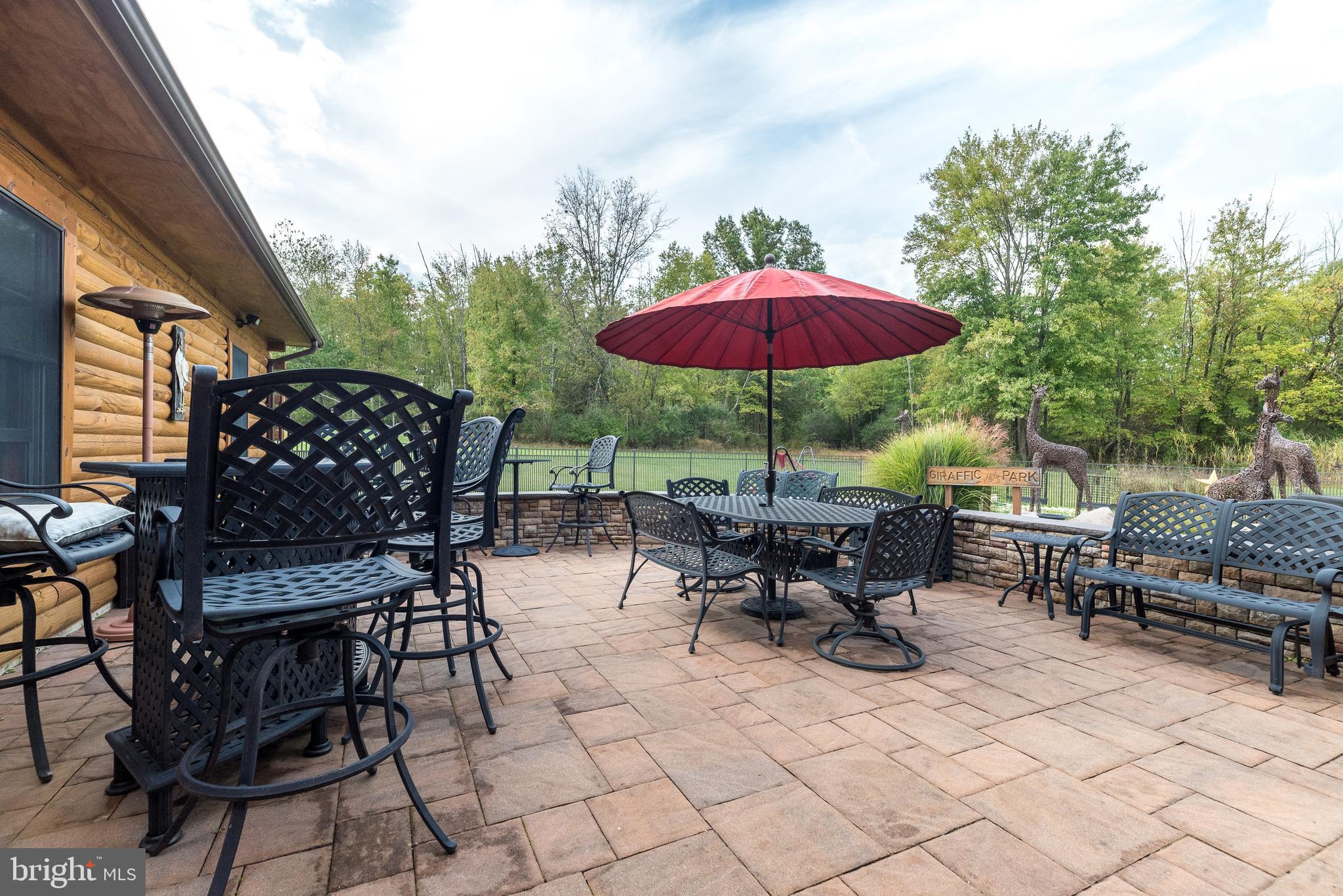 7223 Ferry Road New Hope, PA 18938 - Photo 46 of 87 a view of a patio with table and chairs under an umbrella with a barbeque